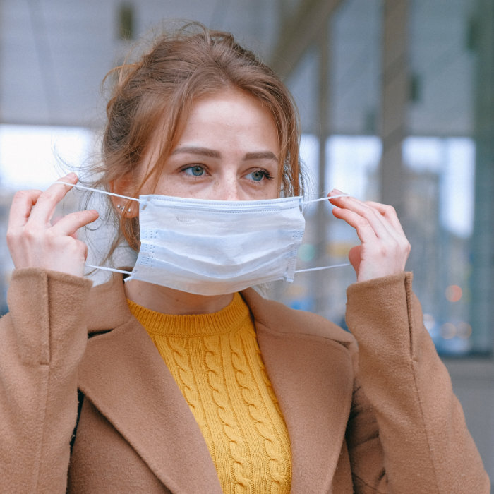 Woman putting face mask on